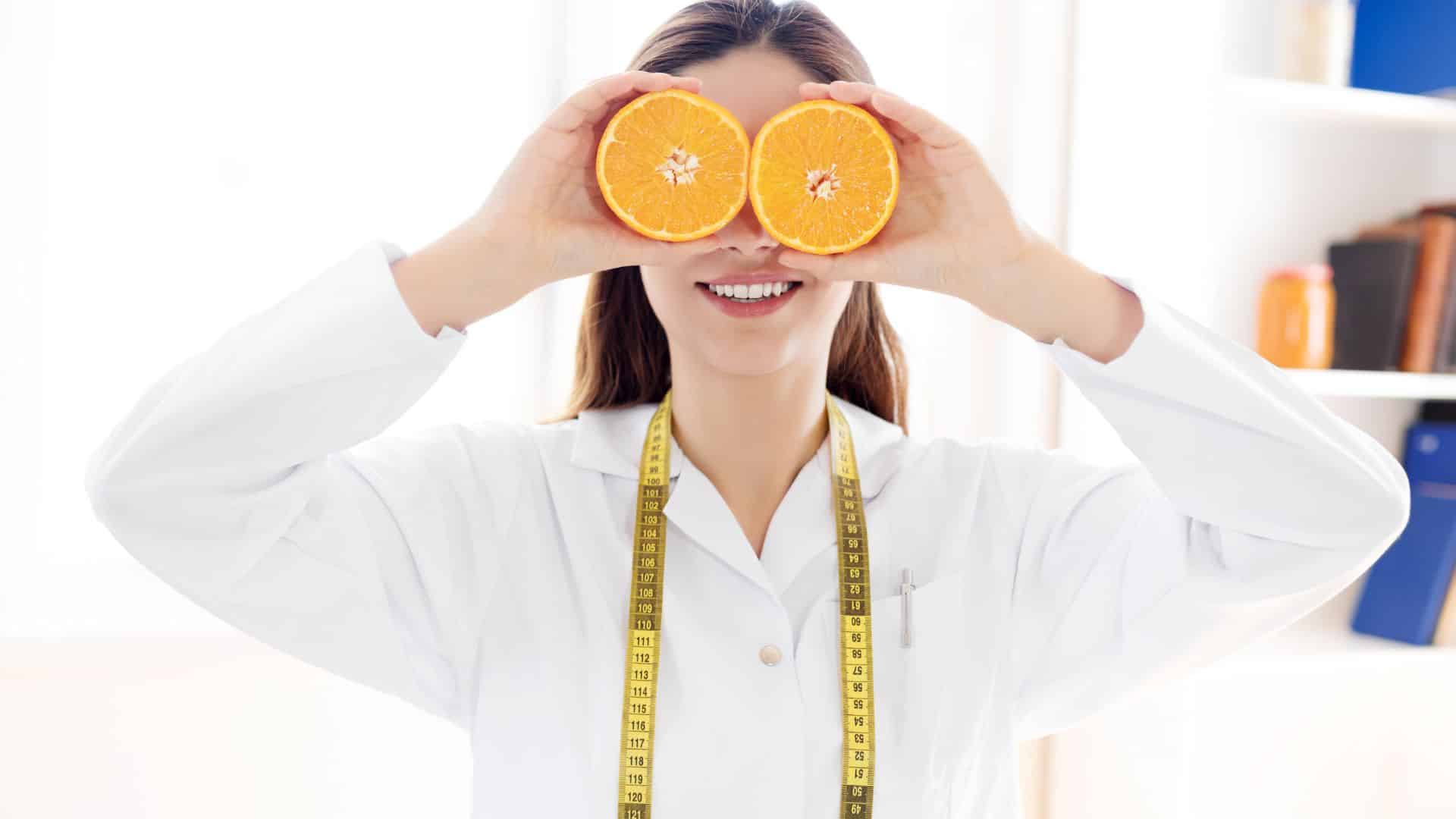 Nutricionista com dois gomos de laranja no lugar dos olhos